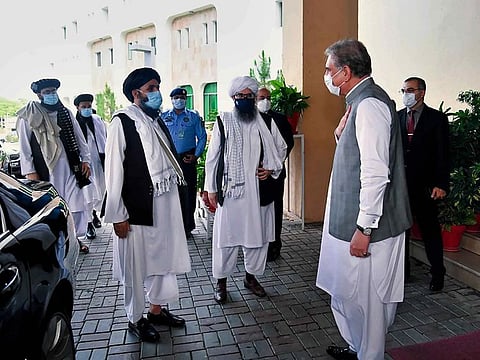 Pakistan's Foreign Minister Shah Mahmood Qureshi, right, greets the Taliban political team on their arrival at the Foreign Ministry for talks, in Islamabad, Pakistan, Tuesday, Aug. 25, 2020