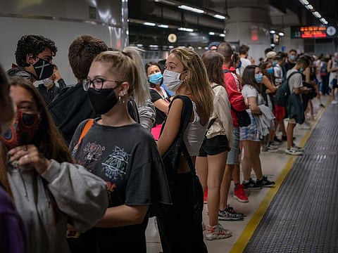 Passengers wearing face masks wait for the train at the main train station in Barcelona, Spain on Tuesday, Sept. 1, 2020