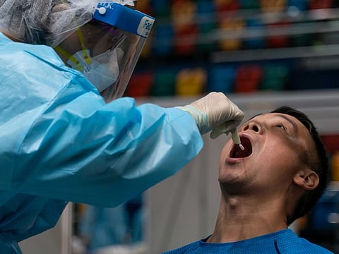 Swab sample is collected from a man by medical staff at the community testing centre for the coronavirus disease (COVID-19) in Hong Kong, China September 1, 2020.