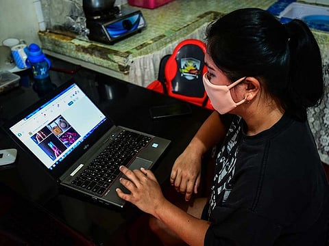 Lorraine Ann Imperio browsing her computer as she prepares to barter goods online in Las Pinas City, suburban Manila.