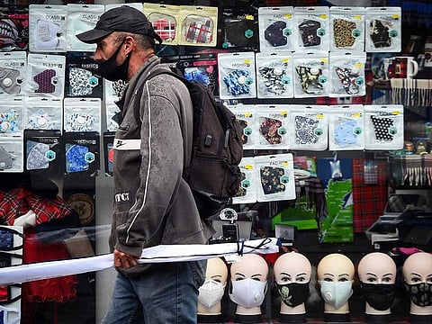 A pedestrian walks past a display of facemasks, being sold due to the COVID-19 pandemic, in Glasgow on September 2, 2020 after the Scottish government imposed fresh restrictions on the city after an rise in cases of the novel coronavirus.