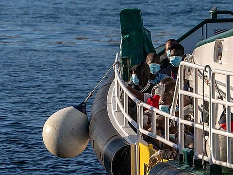 File photo: Migrants wearing face masks sit on the deck of a police rescue boat as they arrive at the Arguineguin port in Gran Canaria island, Spain, after being rescued in the Atlantic Ocean on August 20, 2020.
