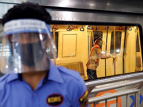 A worker wearing a face shield and mask cleans inside a train at a Delhi Metro station ahead of the restart of its operations, amidst the spread of coronavirus disease (COVID-19), in New Delhi, India, September 3, 2020.
