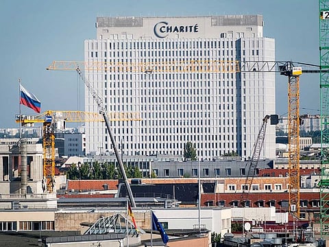 The Russian flag waves on top of the embassy with the central building of the Charite hospital where the Russian opposition leader Alexei Navalny is being treated in the background in Berlin, Germany, Thursday, Sept. 3, 2020. German Chancellor Angela Merkel called the poisoning on Navalny attempted murder on Wednesday and said it was meant to silence one of Russian President Vladimir Putin's fiercest critics. The Berlin hospital treating the dissident said he remains on a ventilator though his condition is improving.
