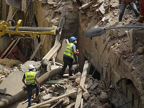 Rescue workers prepare to use a tube to vacuum debris from a badly damaged building in Lebanon's capital Beirut, in search of possible survivors from a mega-blast at the adjacent port one month ago, after scanners detected a pulse, on September 4, 2020.