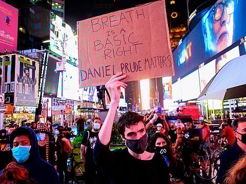 A demonstrator holds a sign as people protest to demand justice for Daniel Prude, on September 3, 2020 in New York City. Protests were planned in New York September 3 over the death of Daniel Prude, a black man that police hooded and forced face down on the road, according to video footage that prompted a probe from the state's attorney general.