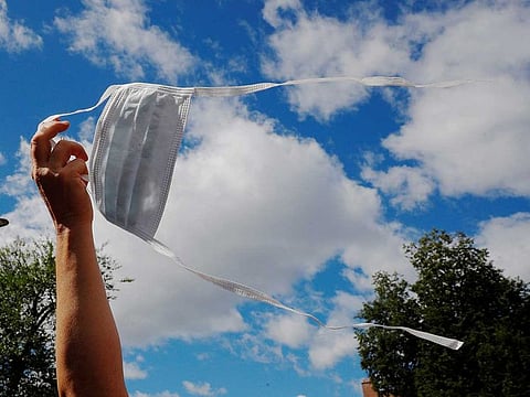 A demonstrator waves his mask in the air instead of wearing it over his nose and mouth during a "No Mandatory Flu Shot Massachusetts" rally against Massachusetts Governor Charlie Baker's order for mandatory influenza vaccinations for all students under the age of 30, an effort to lower the burden on the health care system during the coronavirus disease (COVID-19) outbreak, outside the State House in Boston, Massachusetts, U.S., August 30, 2020.