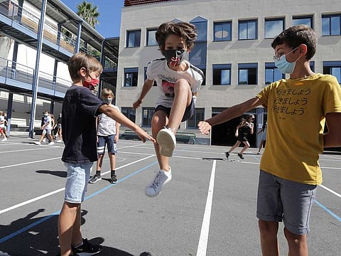 Secondary school students, wearing protective face masks, play in the courtyard at the College Henri Matisse school during its reopening in Nice as French children return to their schools after the summer break with protective face masks and social distancing as part of efforts to curb a resurgence of the coronavirus disease (COVID-19) across France, September 1, 2020.