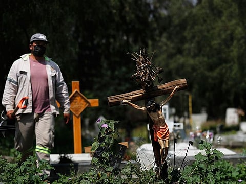 A grave digger walks in the COVID-19 section of the cemetery of San Lorenzo Tezonco Iztapalapa on the outskirts of Mexico City.