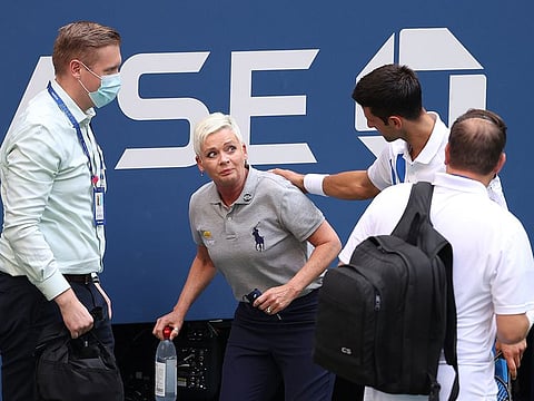 Djokovic comforts the lineswoman after she got to her feet.