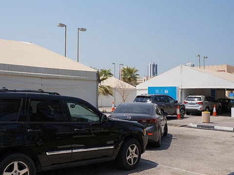 Motorists wait at a drive-through centre for COVID-19 at the Bahrain International Exhibition and Convention Centre.