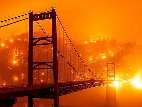 Embers light up a hillside behind the Bidwell Bar Bridge as the Bear Fire burns in Oroville, California.