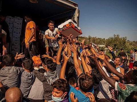 Migrants gather during a food distribution two days after Greece's biggest migrant camp, Moria, was destroyed by fire, on September 10, 2020
