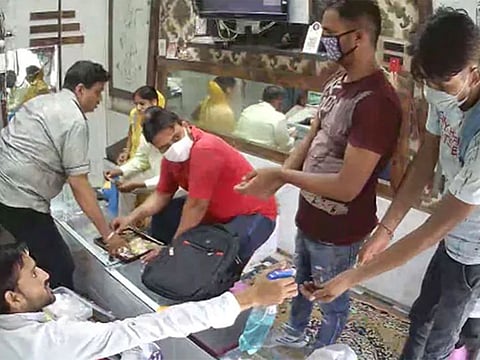 The CCTV footage shared on Twitter shows the robbers calmly sanitise their hands, before proceeding to take their guns out