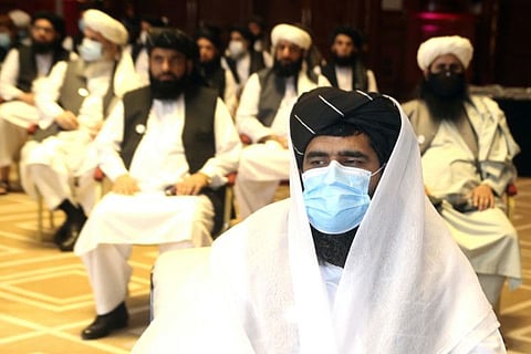 A member of Taliban negotiation delegation, keeps his face mask during the opening session of the peace talks between the Afghan government and the Taliban in Doha on September 12, 2020.