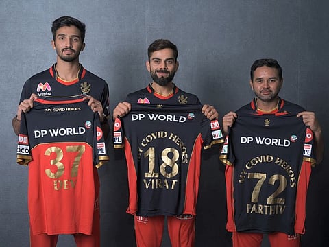 Royal Challengers Bangalore skipper Virat Kohli is flanked by Devdutt Paddikal (left) and Parthiv Patel during the launch of 2020 jerseys on Thursday.