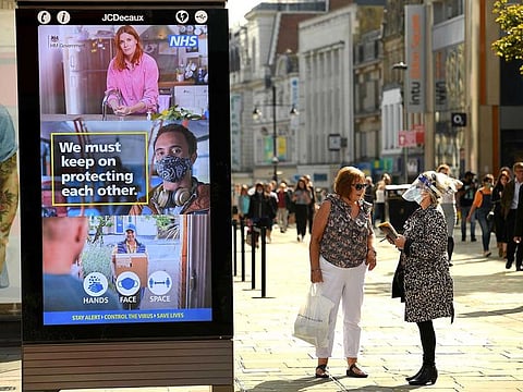 Shoppers walk past an electronic billboard in Newcastle city centre, north-east England (File)