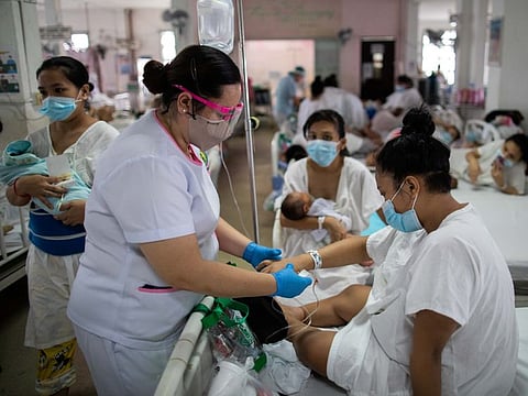 Filipino nurse Marciana Erispe tends to a mother inside the maternity ward of the government-run Dr. Jose Fabella Memorial Hospital, amid the coronavirus disease (COVID-19) outbreak, in Manila, Philippines, September 18, 2020. REUTERS/Eloisa Lopez