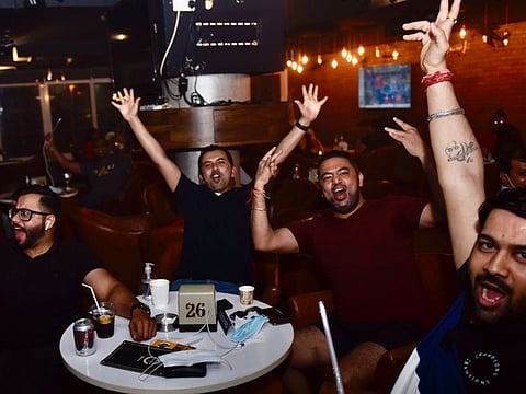 Fans enjoy the first match between Chennai Super Kings and Mumbai Indians at Moon Mood Cafe in Dubai on Saturday..
