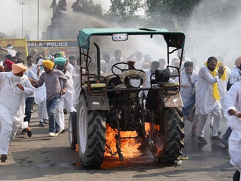 Farmers set a tractor on fire during the protest over Farm Bills, in Ambala on Sunday.