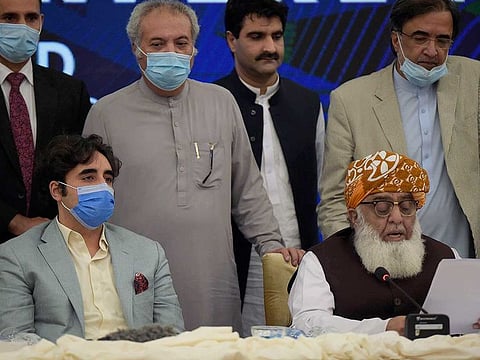 Pakistani opposition parties leaders Maulana Fazal-ur-Rehman, front right, reads out a statement while Bilawal Bhutto Zardari, front left, looks on at a press briefing following their All Parties Conference, in Islamabad, Pakistan, Sunday, Sept. 20. 2020. Pakistani opposition parties demanded immediate resignation of Prime Minister Imran Khan and they launched an alliance to hold a countrywide protest movement against the government.