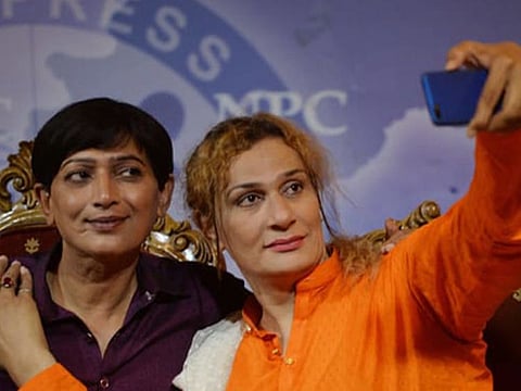 A member of Azad Party taking selfie with the party president Nadeem Kashish (left) after a press conference in Islamabad.