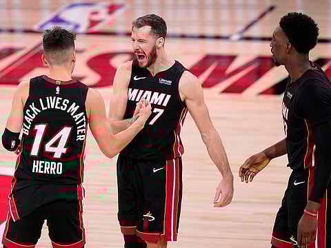Miami Heat's Tyler Herro, left, Goran Dragic and Bam Adebayo celebrate the Game 4 win over Boston Celtics.