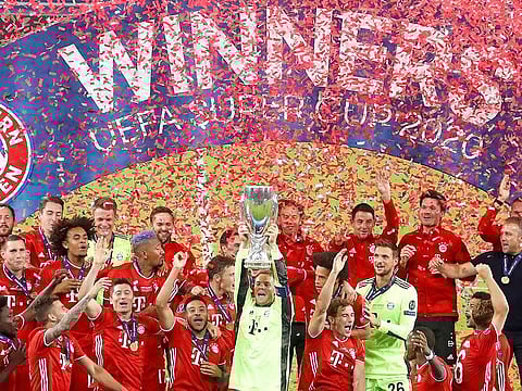 Bayern's goalkeeper Manuel Neuer holds the trophy as teammates celebrate after the UEFA Super Cup final.