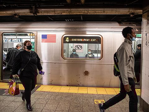 People wearing protective masks exit a subway train at Grand Central in New York.