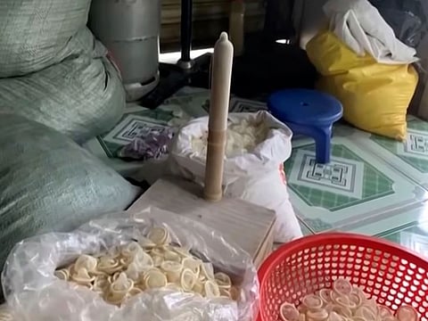 In this image from a video report by VTV, allegedly used condoms are being reshaped before being packed for sale in Binh Duong province, Vietnam.