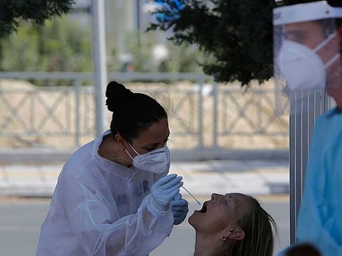 A health worker carries out a COVID-19 test of a resident of Larnaca, a resort town in southern coast of Cyprus.