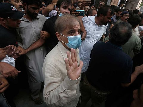 Pakistani opposition leader Shahbaz Sharif waves while being escorted by officials at Lahore High Court after his bail was rejected, in Lahore, Pakistan, Monday, Sept. 28, 2020.