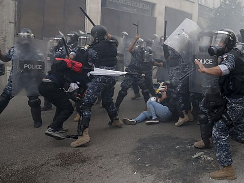 In this Septemeber 1, 2020 file photo, riot policemen beat anti-government protesters during a protest near Parliament Square, in Beirut, Lebanon.