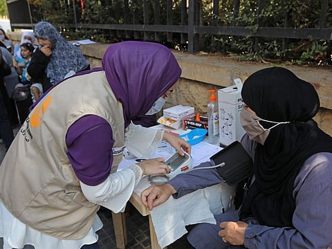 Women wait for their turn outside a mobile clinic supported by the United Nations Population Fund (UNFPA), offering free ultrasounds and tests before referring women to other health centres, in Beirut's Basta neighbourhood on September 18, 2020.