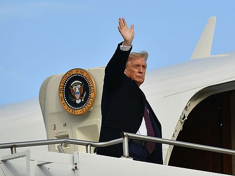 US President Donald Trump waves as he boards Air Force One before departing from Andrews Air Force Base in Maryland on October 1, 2020.