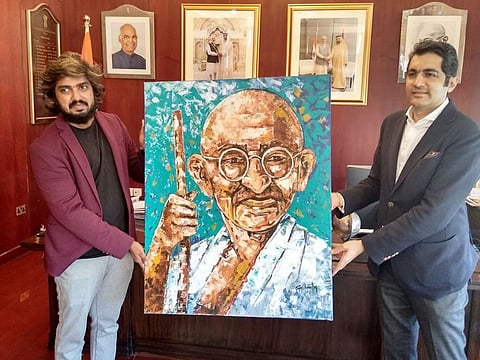 Sijin Gopinathan hands over the Mahatma's portrait to Consul General of India Aman Puri in Dubai.
