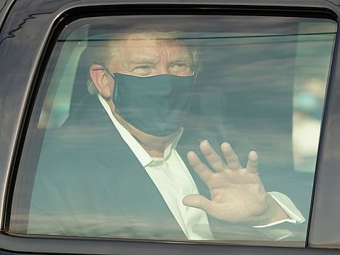 A car with US President Trump drives past supporters in a motorcade outside of Walter Reed Medical Center in Bethesda, Maryland on October 4, 2020.