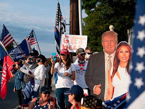 Supporters of the US president hold flags as they rally outside of Walter Reed Medical Center in Bethesda, Maryland on October 4, 2020, where the president is being treated for COVID-19.