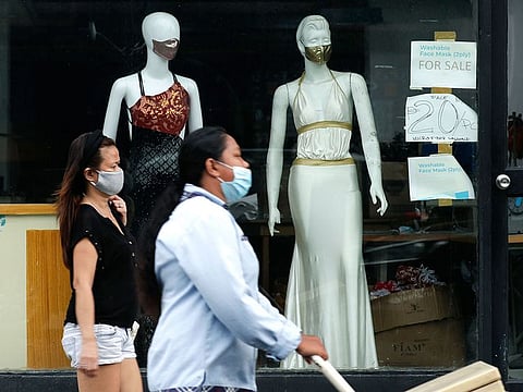 Women walk past mannequins wearing face masks advertised for sale, at a shop in Makati city, Philippines.