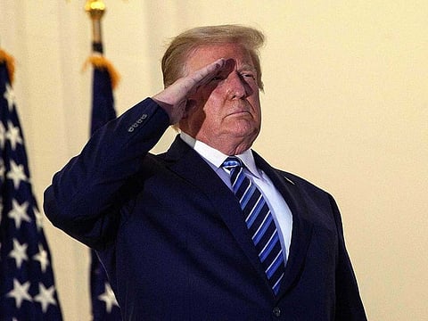 US President Donald Trump salutes from the Truman Balcony in White House