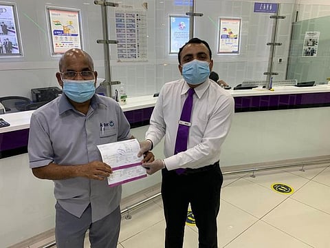 A Mawarid Exchange staff member honours a healthcare worker with the company’s offer