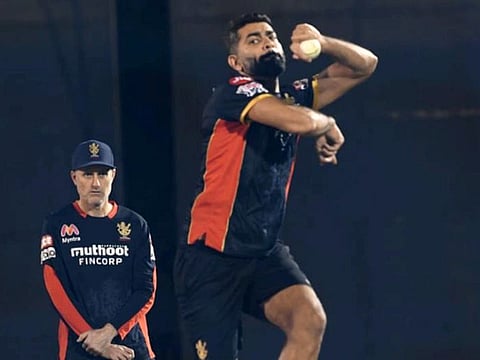 Ahmed Raza, the UAE captain, bowls at the RCB nets as batting coach Simon Katich keeps an eye in Dubai.