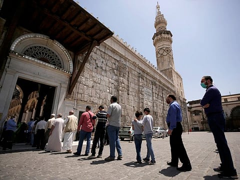 People wear face masks as they wait in line to enter and attend the Friday prayers, after the government has eased the restrictions amid concerns over the coronavirus disease outbreak, at Umayyad mosque in Damascus, Syria May 8, 2020.