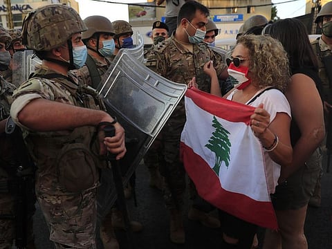 Lebanese army soldiers try to push back anti-government protesters blocking a main highway that links Beirut with north Lebanon during a protest against rising prices and worsening economic and financial conditions, in Zalka, north of Beirut on October 5, 2020.