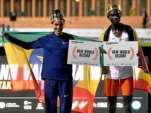 Ethiopian athlete Letesenbet Gidey (L) and Ugandan athlete Joshua Cheptegei pose after breaking the 5,000m and 10,000m track world records, respectively, during the NN Valencia World Record Day at the Turia stadium in Valencia on October 7, 2020.