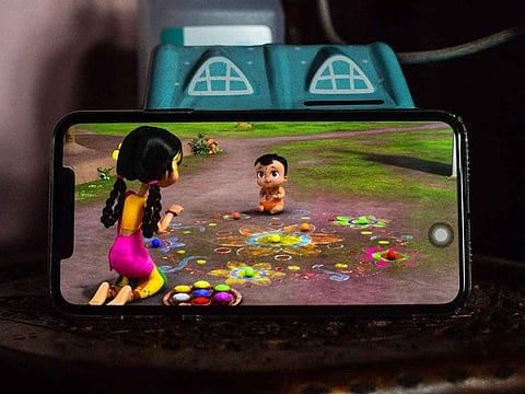 A child watches 'Mighty Little Bheem' cartoon series on a mobile phone.