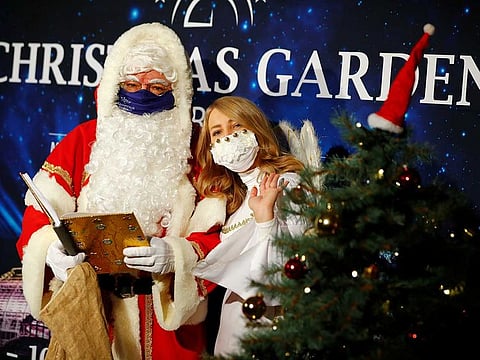 A man dressed as Santa Claus and woman dressed as angel wear face masks ahead of a news conference to introduce the upcoming Christmas Garden event of iluminated objects at a botanic garden, amid the coronavirus disease (COVID-19) outbreak, in Berlin, Germany, October 8, 2020.