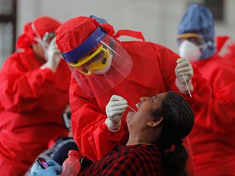 Sri Lankan health officials take swab samples from employees of the Colombo municipal council to test for COVID-19 in Colombo, Sri Lanka, Wednesday, Oct. 7, 2020.