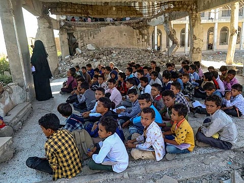 Yemeni pupils attend class on the first day of the new academic year, in a makeshift classroom in their school compound which was heavily damaged two years ago in an air strike, in the country's third-city of Taez on October 7, 2020.