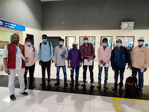 S.V. Reddy (left) with the last batch of stranded Indian workers, who flew home from Dubai International Airport on Friday.